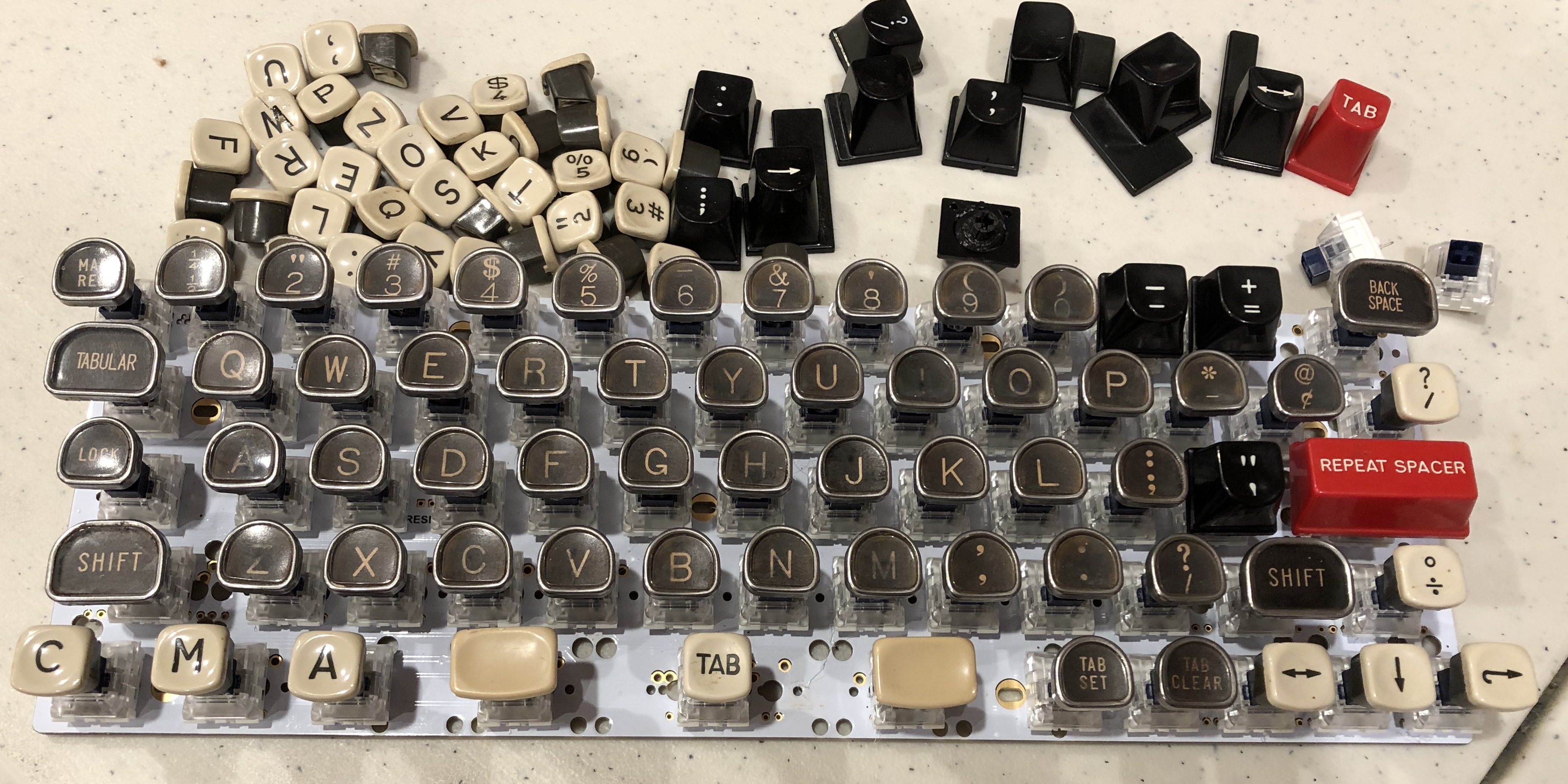Picture of typewriter keyboard without case, with more typewriter keys clustered near it
